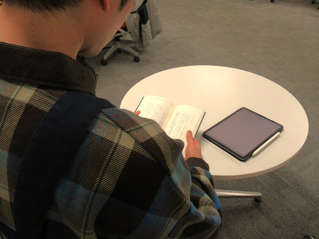 机で読書するLSを後ろから写した写真。机にはiPadが置いてある